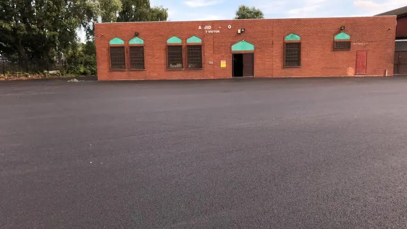 Resurfaced yard outside a brick building